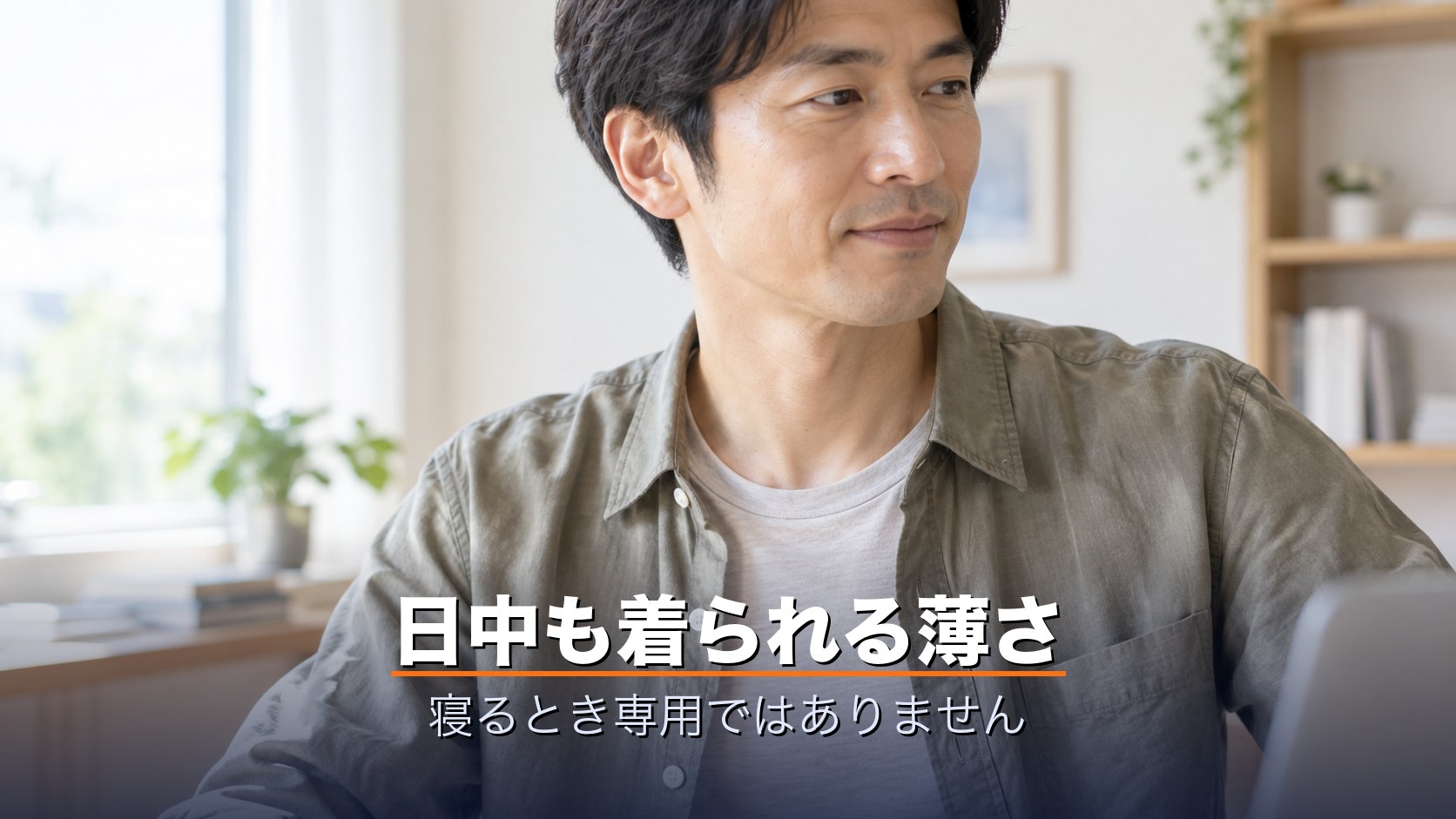 薄手のリカバリーインナーをシャツの下に着て日中デスクで過ごす男性