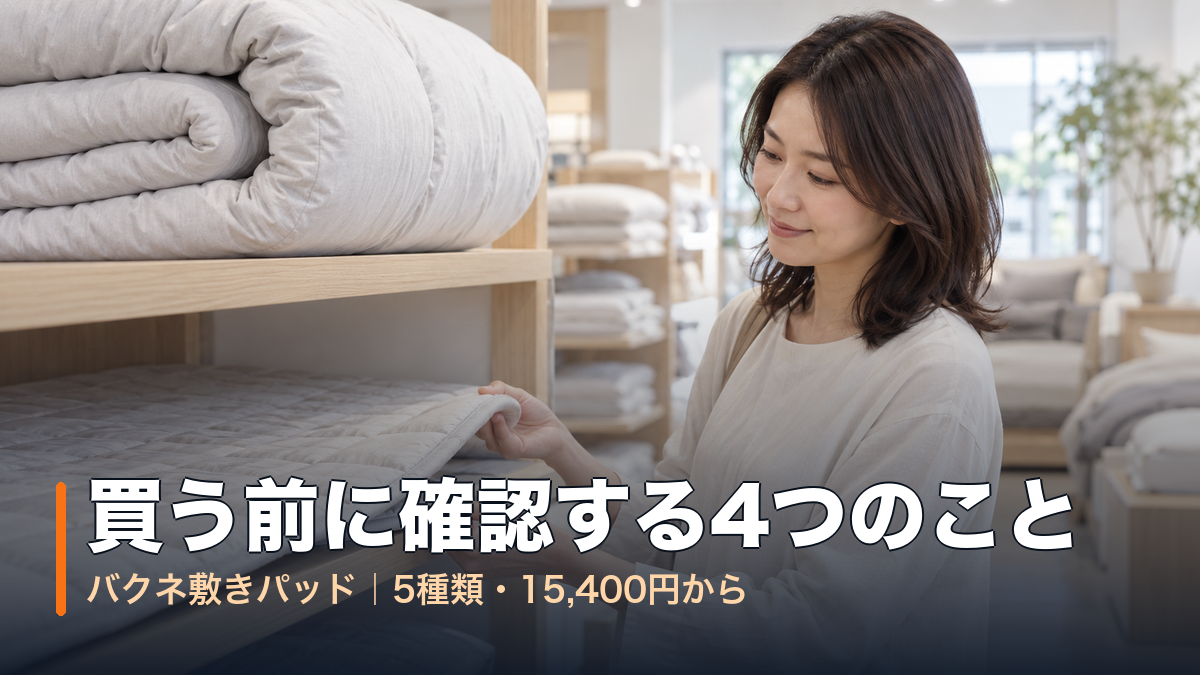 寝具売り場で厚い掛け布団の下にある薄い敷きパッドの角を持ち上げて見る女性｜バクネ敷きパッドは買う前に確認する4つのこと